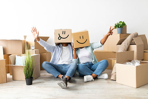 Couple with boxes on heads in a new home