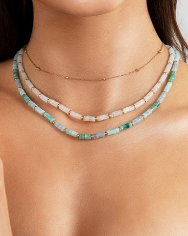 Jewellery trends 2022; a woman wearing layered beaded necklaces