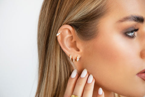 How to clean earrings at home: A woman wearing stacked diamante huggie hoop earrings