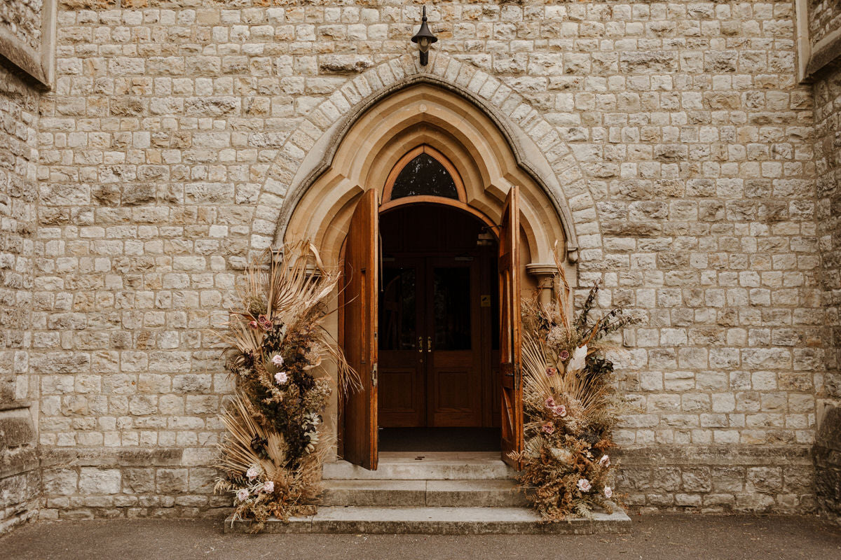 The door of the church, flanked with dried florals.