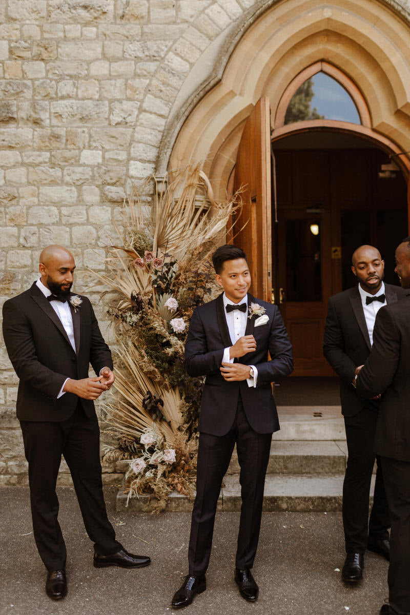 Groom Patrick and his groomsmen stand outside the church.
