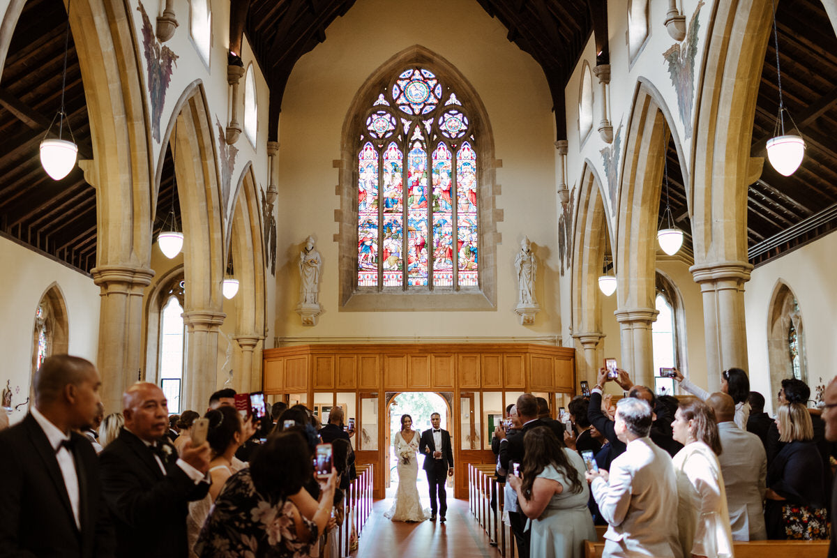 Bride Charlotte walks up the aisle of the church during the wedding ceremony.