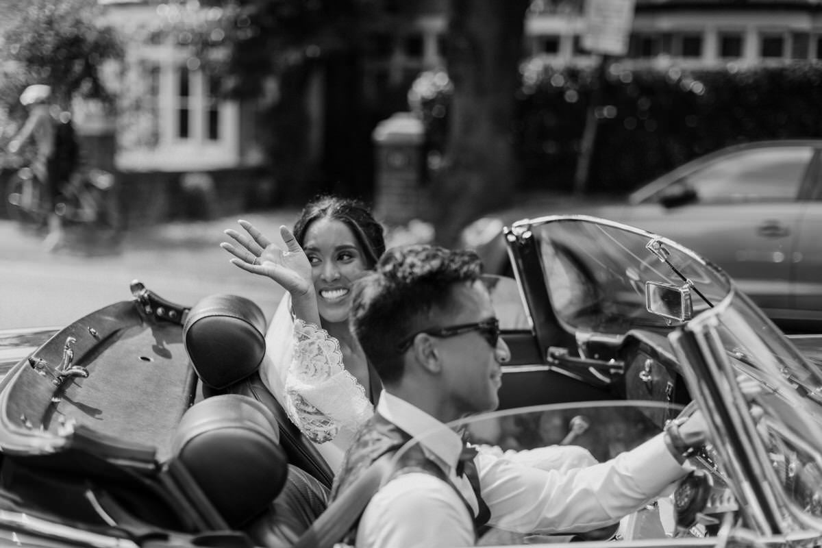 Bride and groom leave the church in a vintage car.