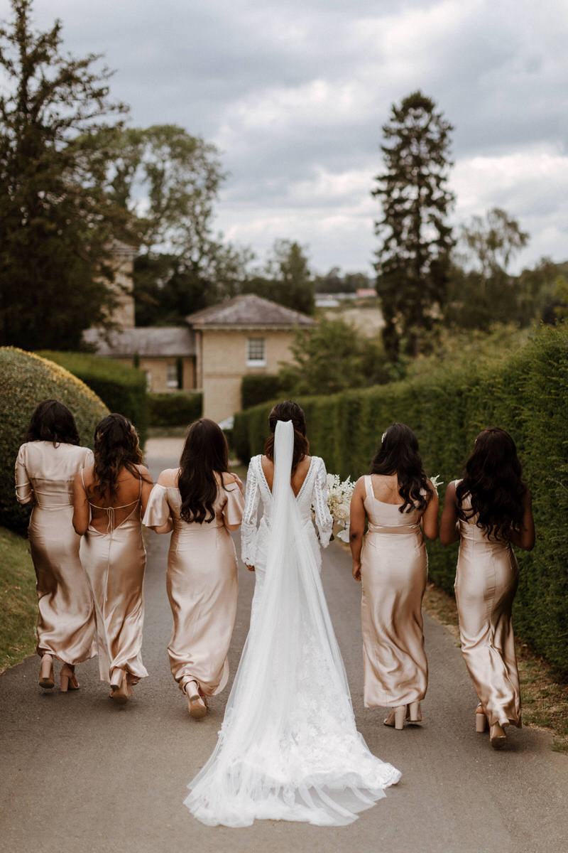 Bride and bridesmaids walk in the grounds of Hedsor House.