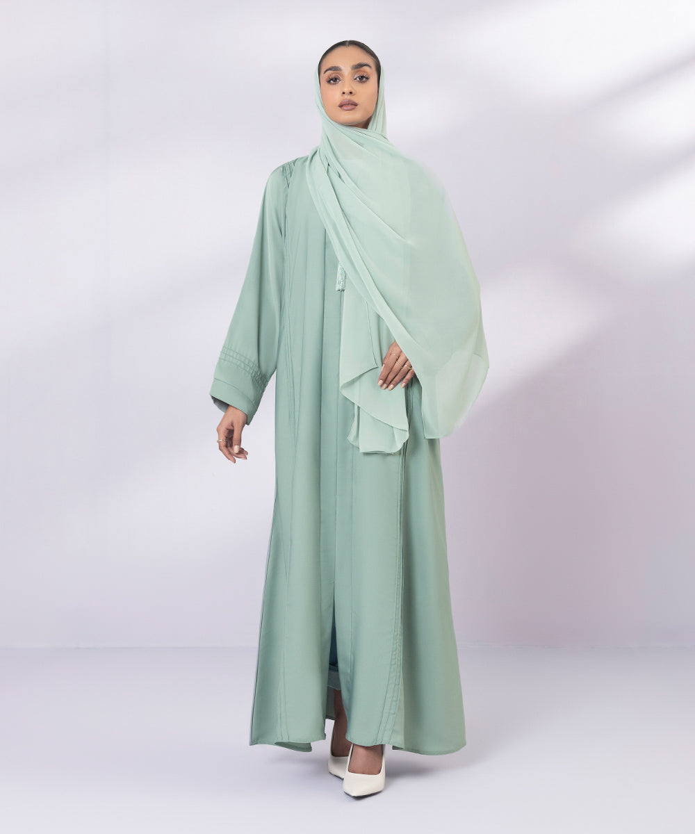 Light green button through abaya with tassel details and pastel green hijab