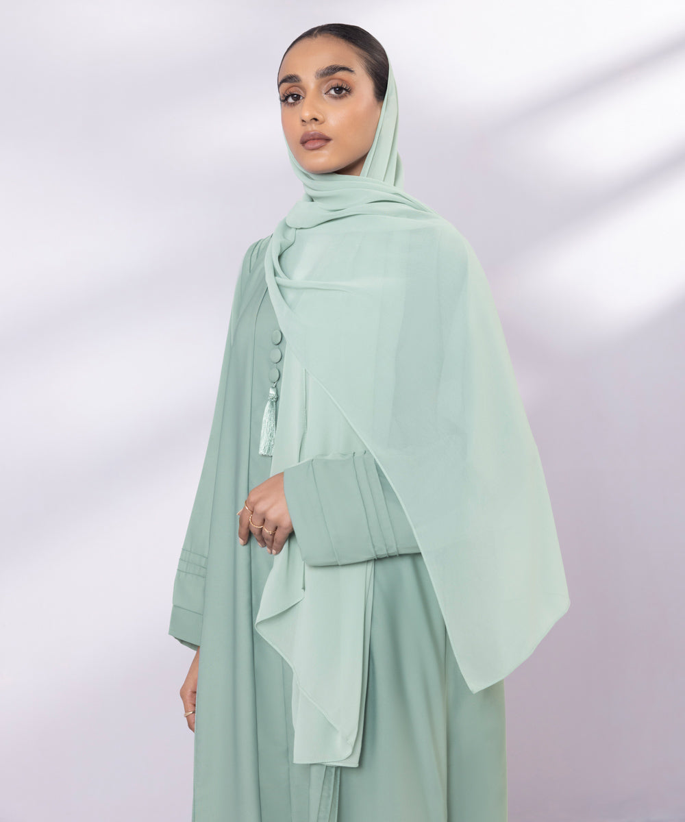 Light green button through abaya with tassel details and pastel green hijab