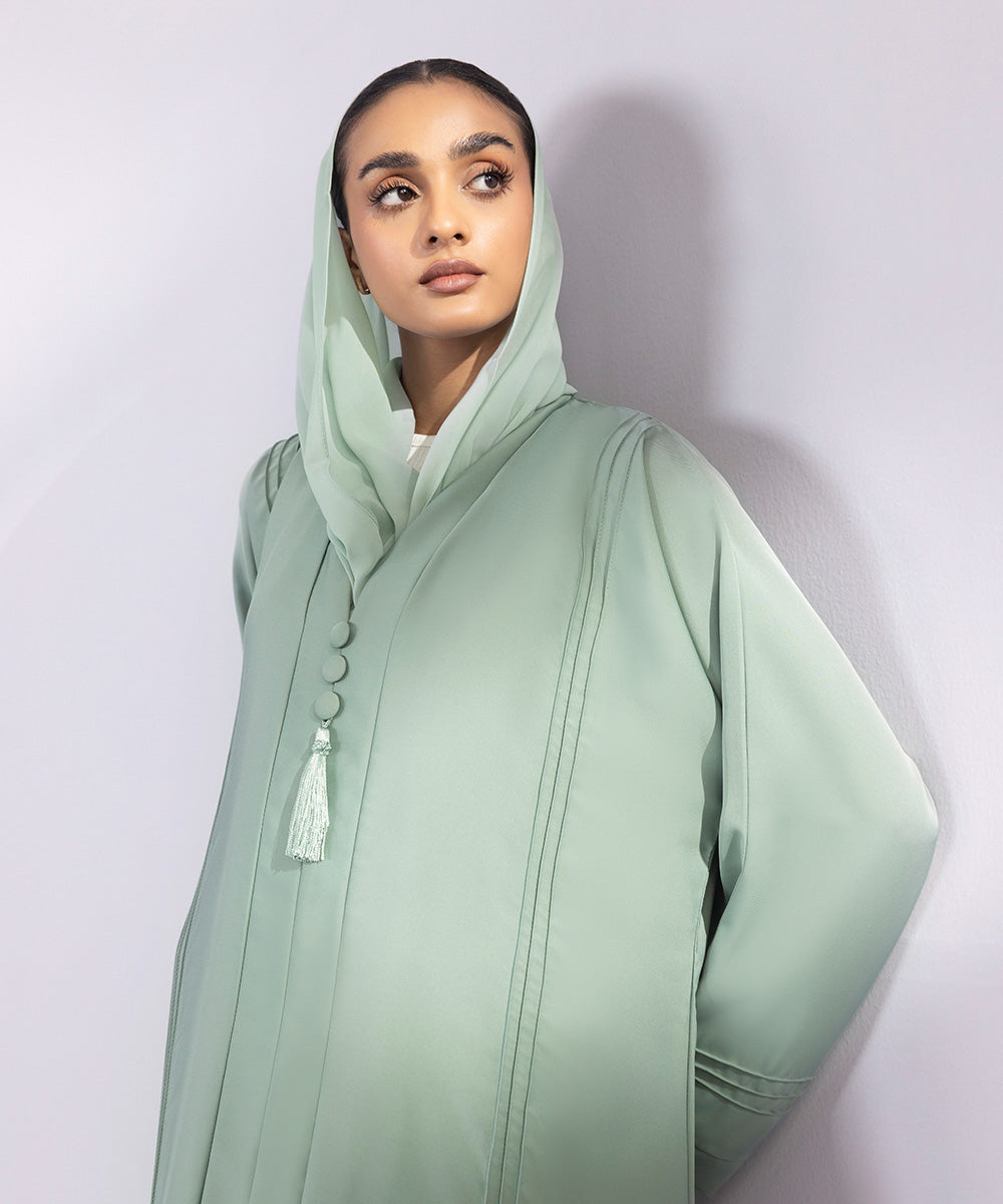 Light green button through abaya with tassel details and pastel green hijab