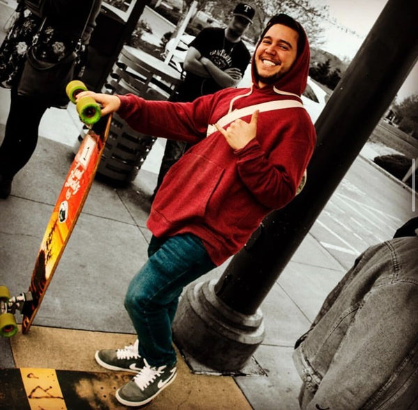 Brett stands posing with longboard