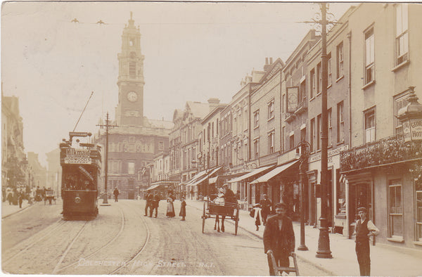 Old real photo postcard of Colchester High Street in Essex