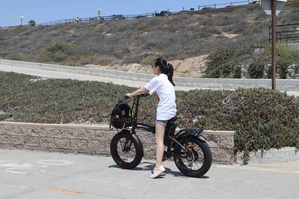 girl riding civi bikes rebel 1.0 electric bike outside near beach