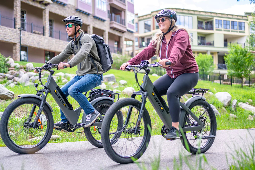 couple riding quietkat step thru electric bikes