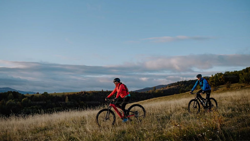 Two people on their electric bikes going down the hill.