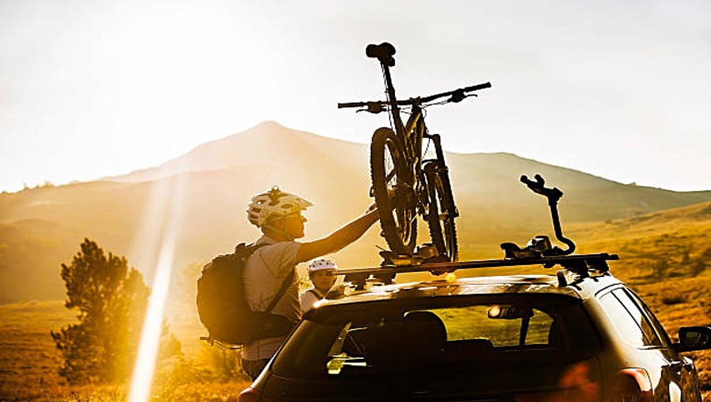 An ebike being loaded on top of the car.