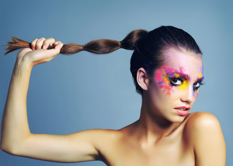 woman with painted face holding bubble braid in hand