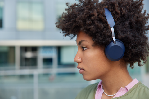 curly haired woman with earphones