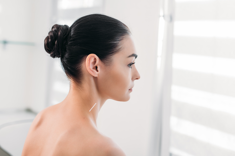 side view of beautiful woman with hair tied up in braided bun