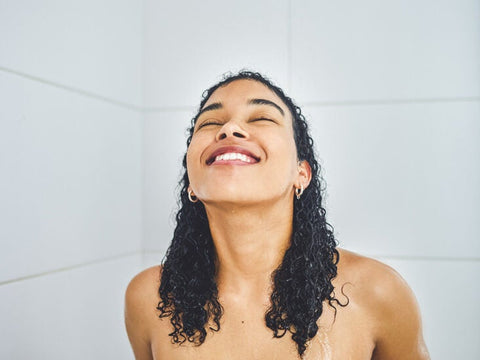 curly haired woman under the shower