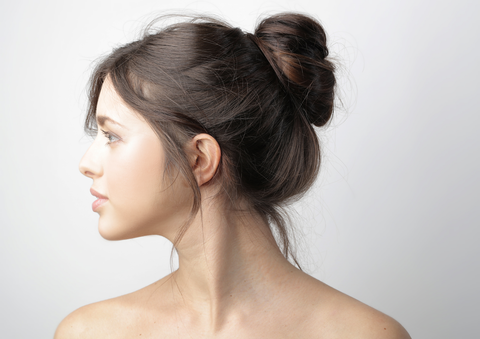 side profile of woman's hair in a messy bun