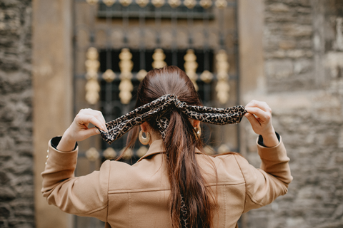 woman tying scarf around ponytail