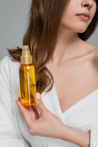 close up of beautiful woman holding a bottle of serum