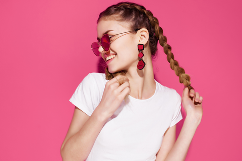 happy woman holding hair that is tied in braids