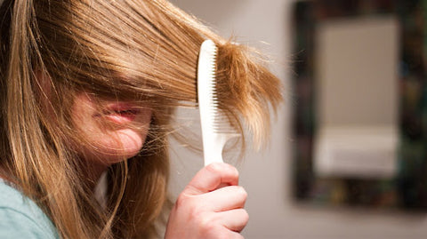 Lady putting comb through hair
