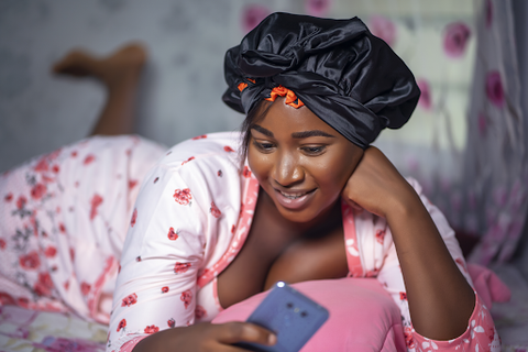 woman wearing silk bonnet talking on phone