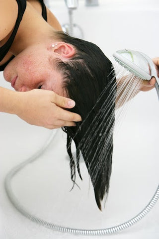 woman washing hair over sink