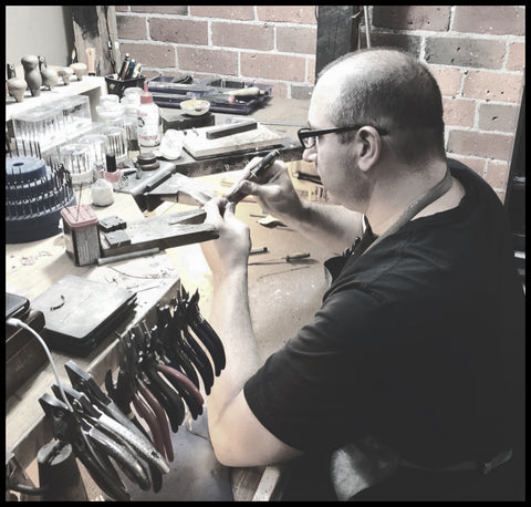 Heath Lyons Jeweller sitting at his workbench finishing a jewellery repair | Bendigo