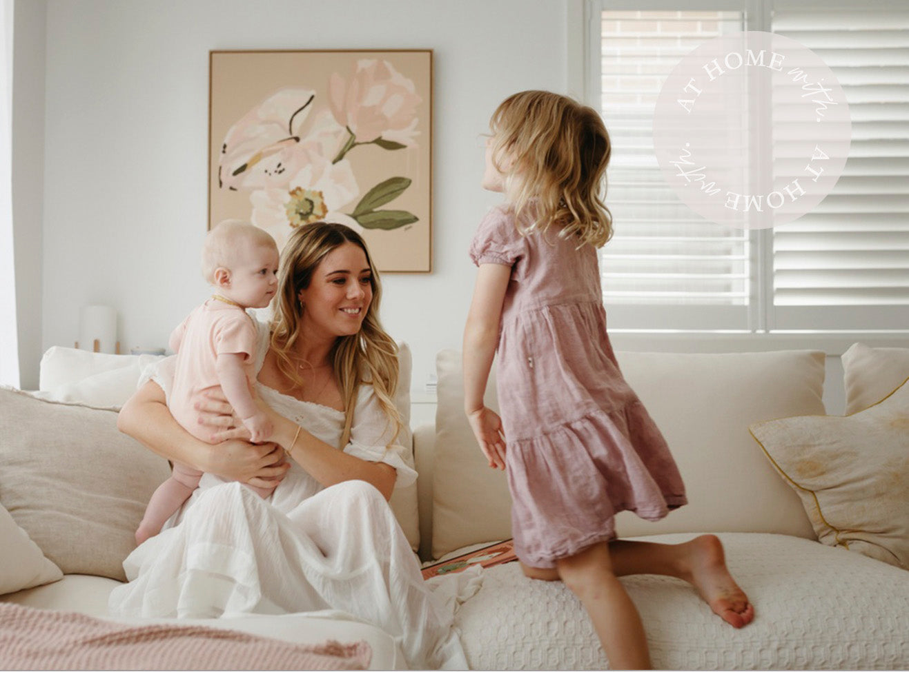 Leah and her young daughters on a couch playing