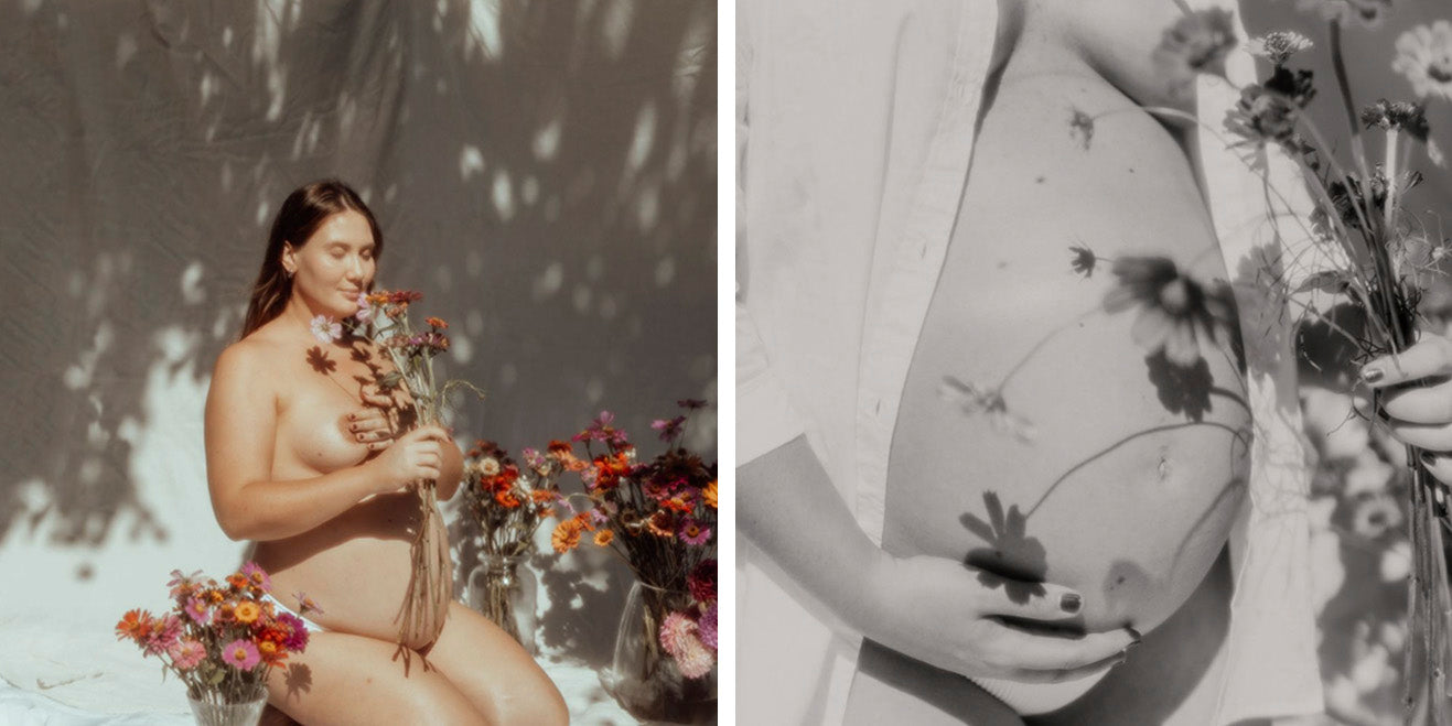 Naked women embracing her baby bump surrounded by flowers