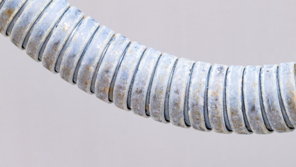 A shower hose with limescale and rust