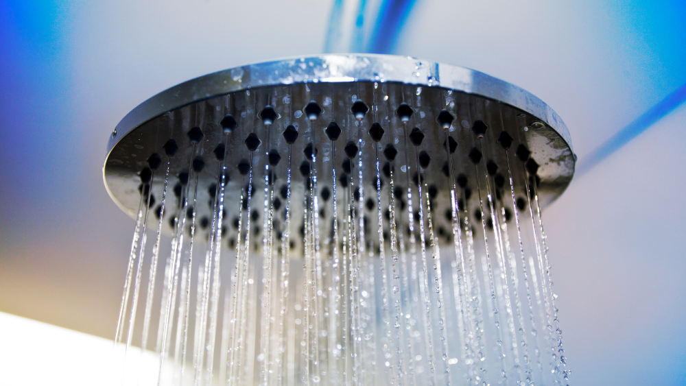 A shower head running cold water - a simple way to get cold shower benefits