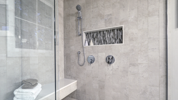 A walk in doorless shower with glass partition and modern tile