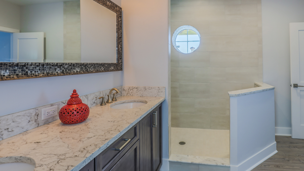 A doorless shower with a half wall and circle window