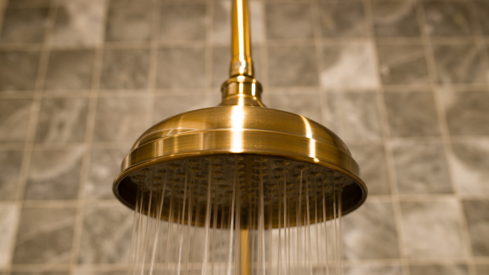 a gold shower head with running water