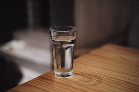 A clear glass of water on a wooden table