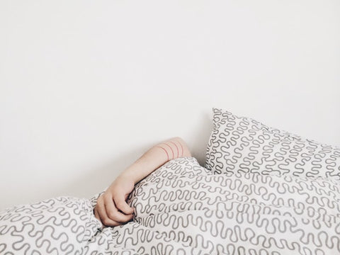 person sleeping under a pile of pillows