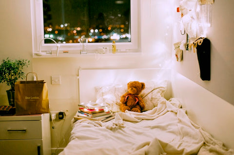 bear and a pile of books in a bed