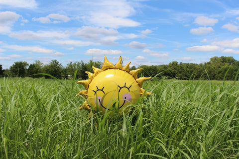 inflatable yellow balloon in a green field