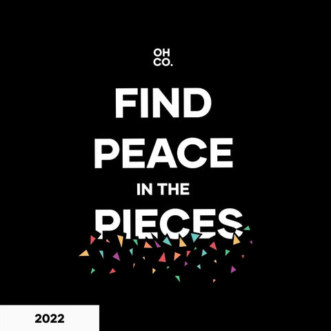 black background with the words "find peace in the pieces" and small colorful triangles being broken off at the bottom