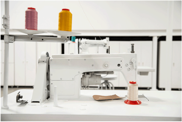 A white backdrop, complete with the hand-painted sewing machines, is intended to make the colors of the craft pop.