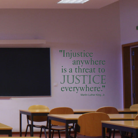 Large dark green wall decal displayed on a school classroom wall that reads: “Injustice anywhere is a threat to justice everywhere.” Martin Luther King, Jr.