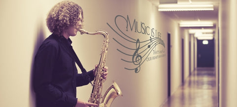 Music wall decal featuring inspiring quote "Music is life, that's why our hearts have beats." decorates school hallway near band room, promoting music education.