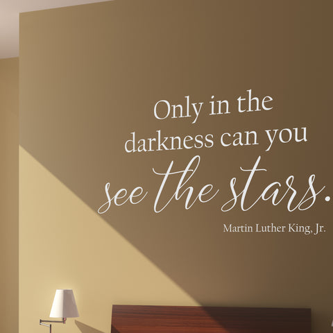 A removable vinyl wall decal shown in white on a beige wall that reads: "Only in the darkness can you see the stars." Martin Luther King Jr.