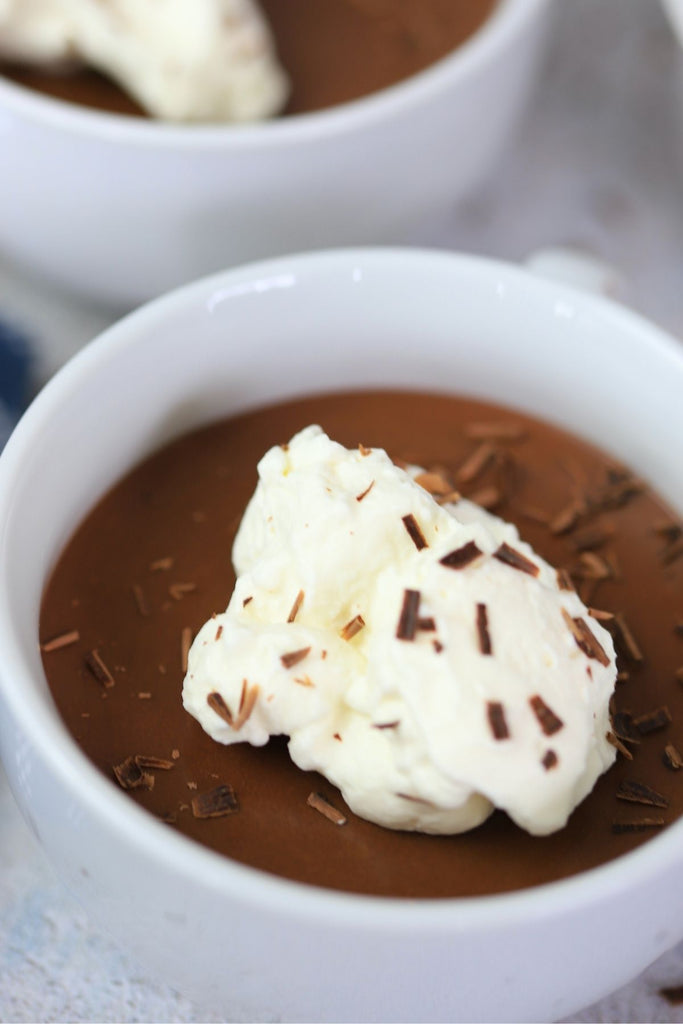 bowl of chocolate mousse topped with whipped cream