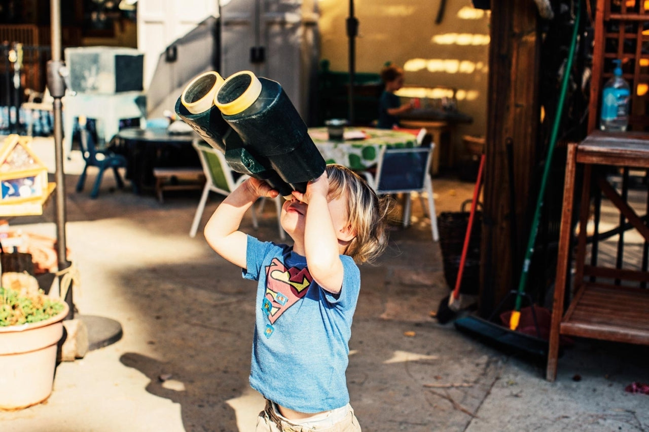Little kid looking up to the sky through giant binoculars. Photo: Kyle Sparks
