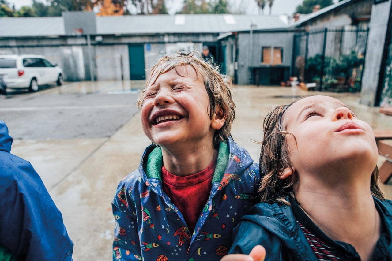 Kids squinting outside, feeling the rain on their face. Photo: Kyle Sparks