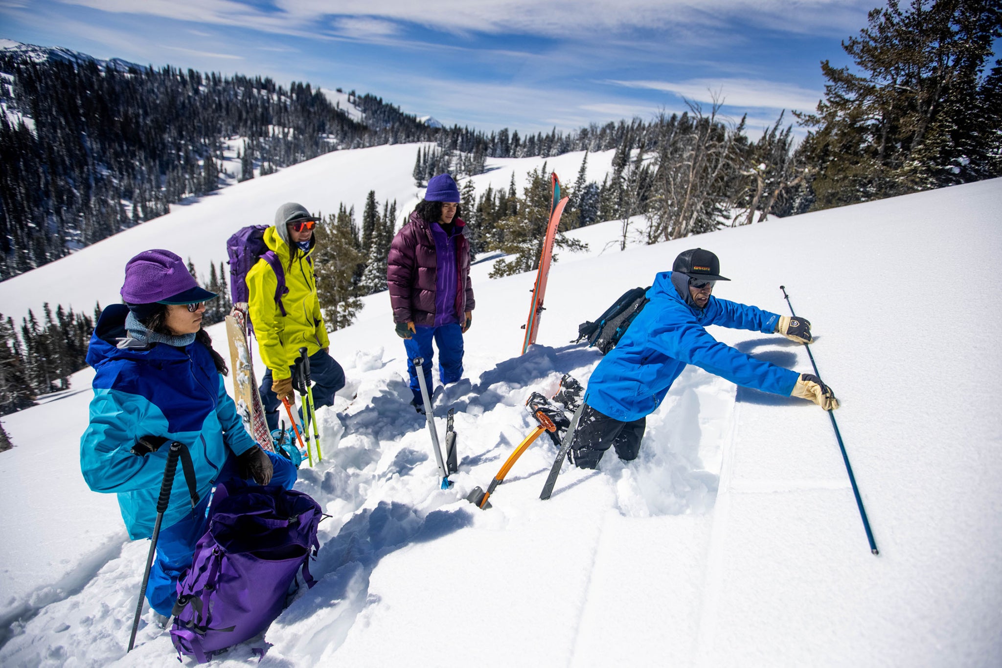 Sheena Dhamsania, Dani Reyes-Acosta and Zynobia (left to right) watch intently as Zahan Billimoria digs to expose a deep, persistent weak layer during a three-day backcountry snow safety course. Teton Range, Wyoming.