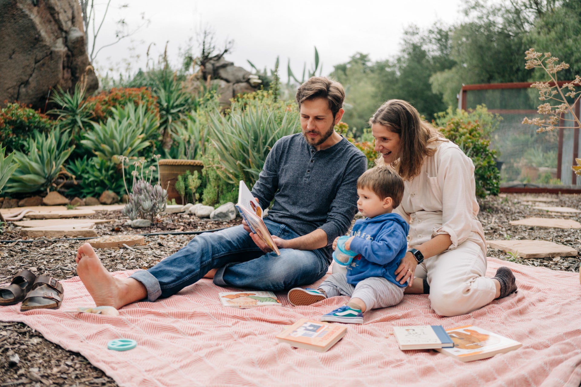 The best seat in the house for story time. Ian, Erna and their son Marty sit buried in books in their backyard.